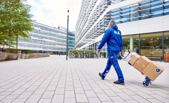 GLS-työntekijä kuljettaa paketteja kaupungilla 
