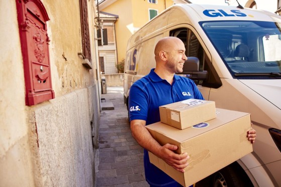 GLS employee holding two parcels and smiling