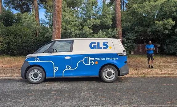 A GLS delivery driver uses an electric van in GLS colors