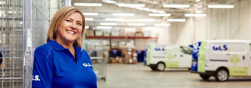  A GLS woman stands smiling in a GLS depot
